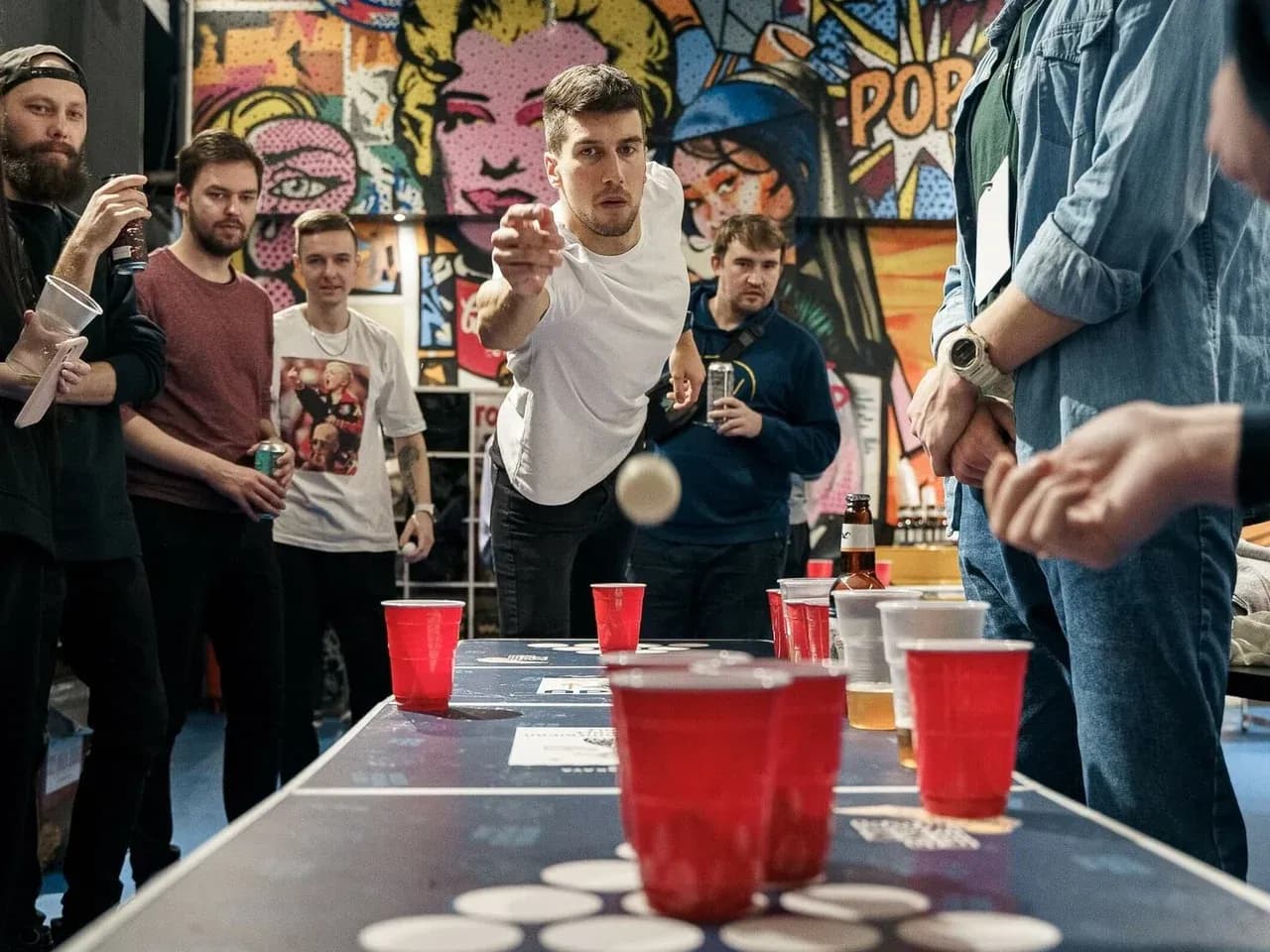Игра Beer Pong на мероприятии: бросок мяча в стаканы на игровом столе