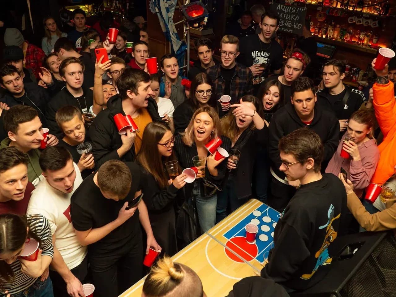 Бир понг на вечеринке: игровая зона Beer Pong с участниками и зрителями