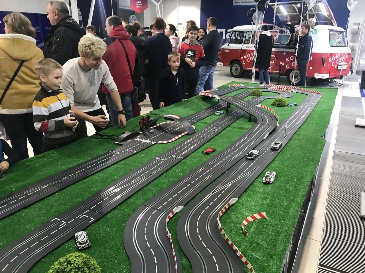 Гости смотрят заезд на треке slot-car — интерактив гонки на велотренажёрах