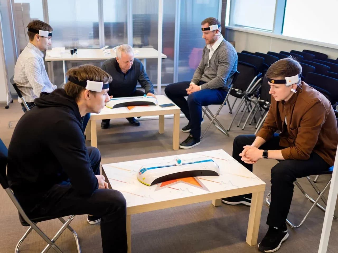 Игра разума для компании: несколько участников за столами Mindball