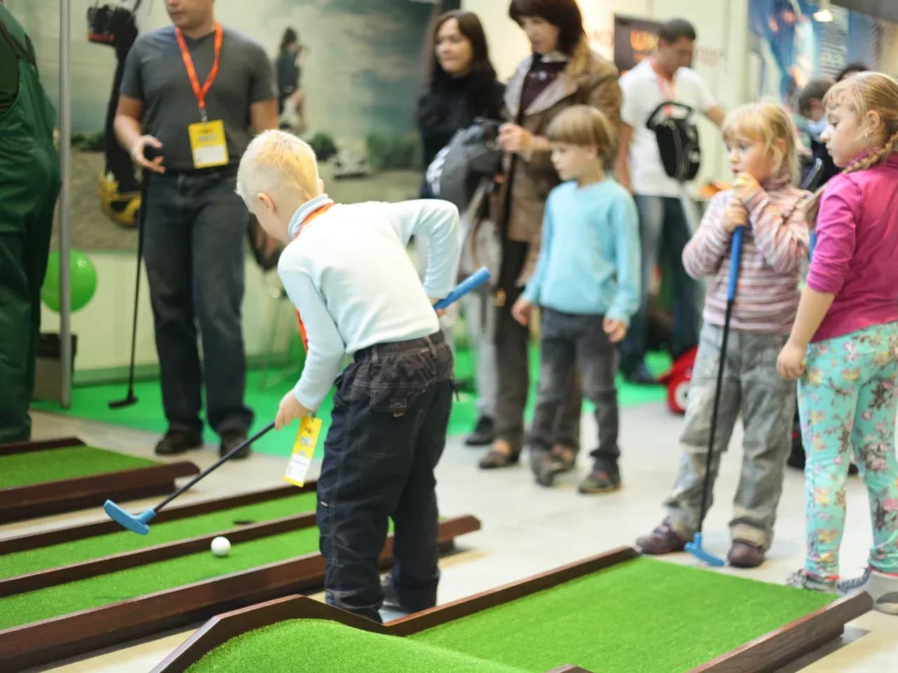 Мини гольф для детей: участник проходит дорожку на мероприятии