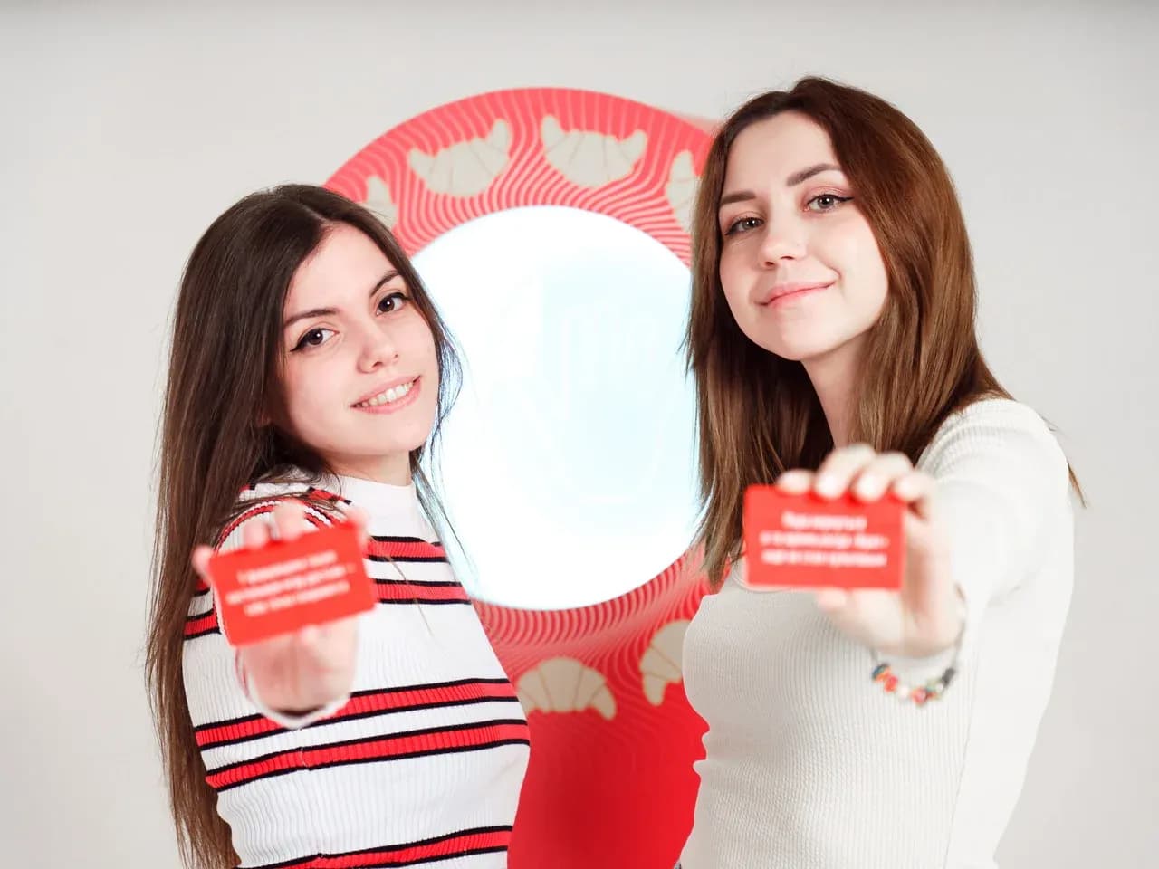 Две девушки держат в руках карточки с предсказаниями