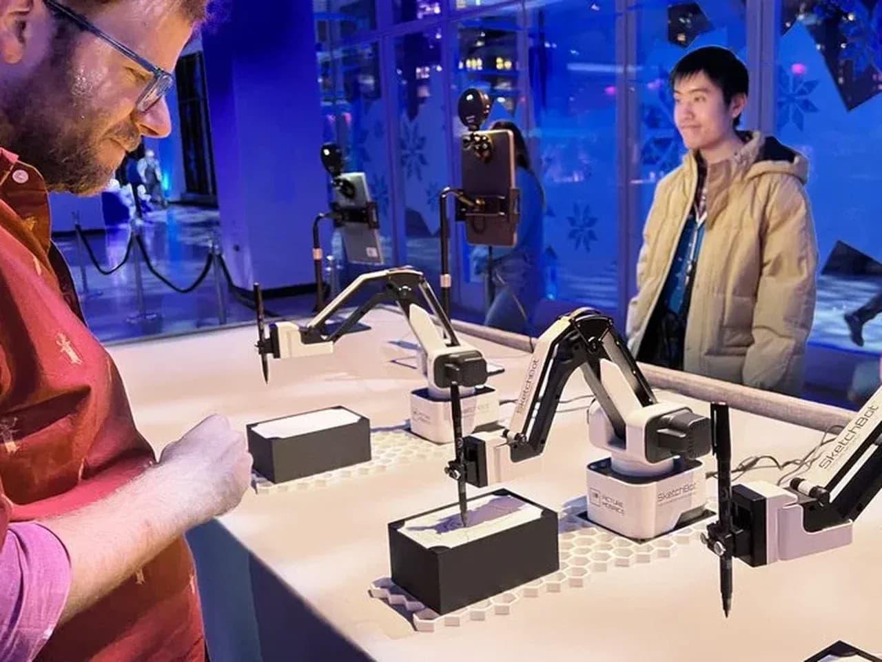 Гость смотрит на процесс рисования портрета