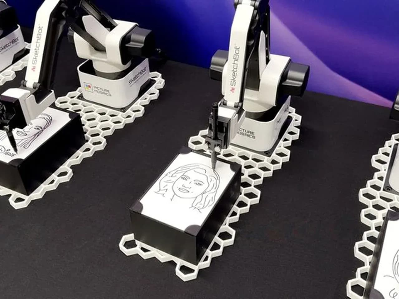 Скетч бот крупным планом: робот-манипулятор рисует портрет на карточке