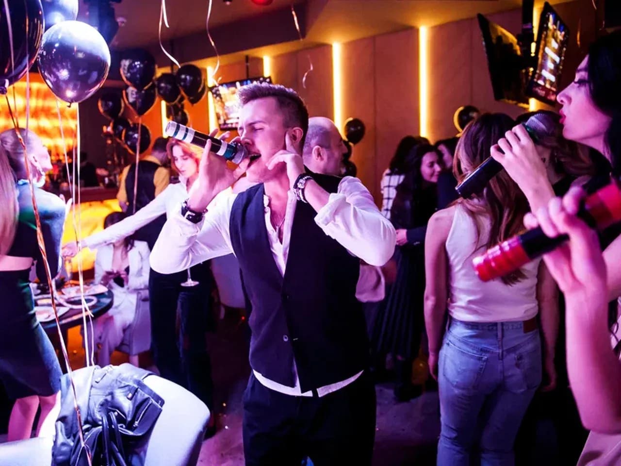 Экстремальное караоке на вечеринке: участник поёт в микрофон, гости поддерживают