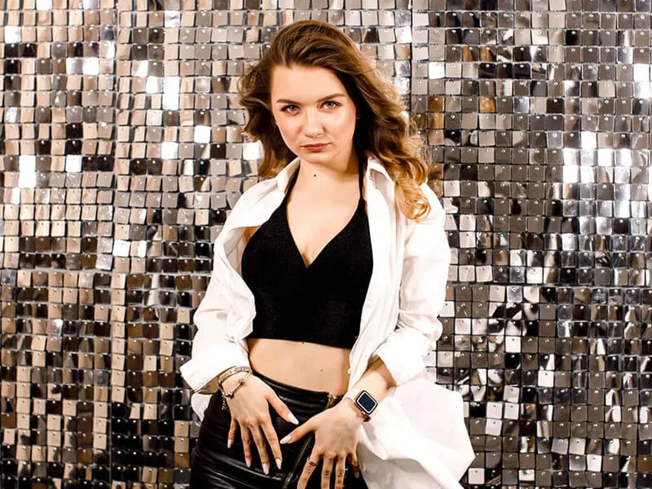 Девушка фотографируется на фоне пайеток