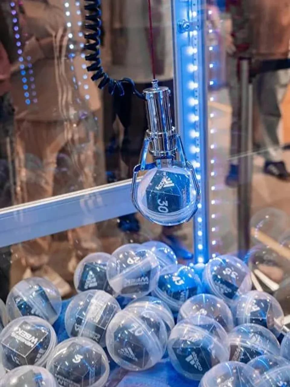 Автомат «Хватайка»: клешня захватывает капсулу с призом, крупный план