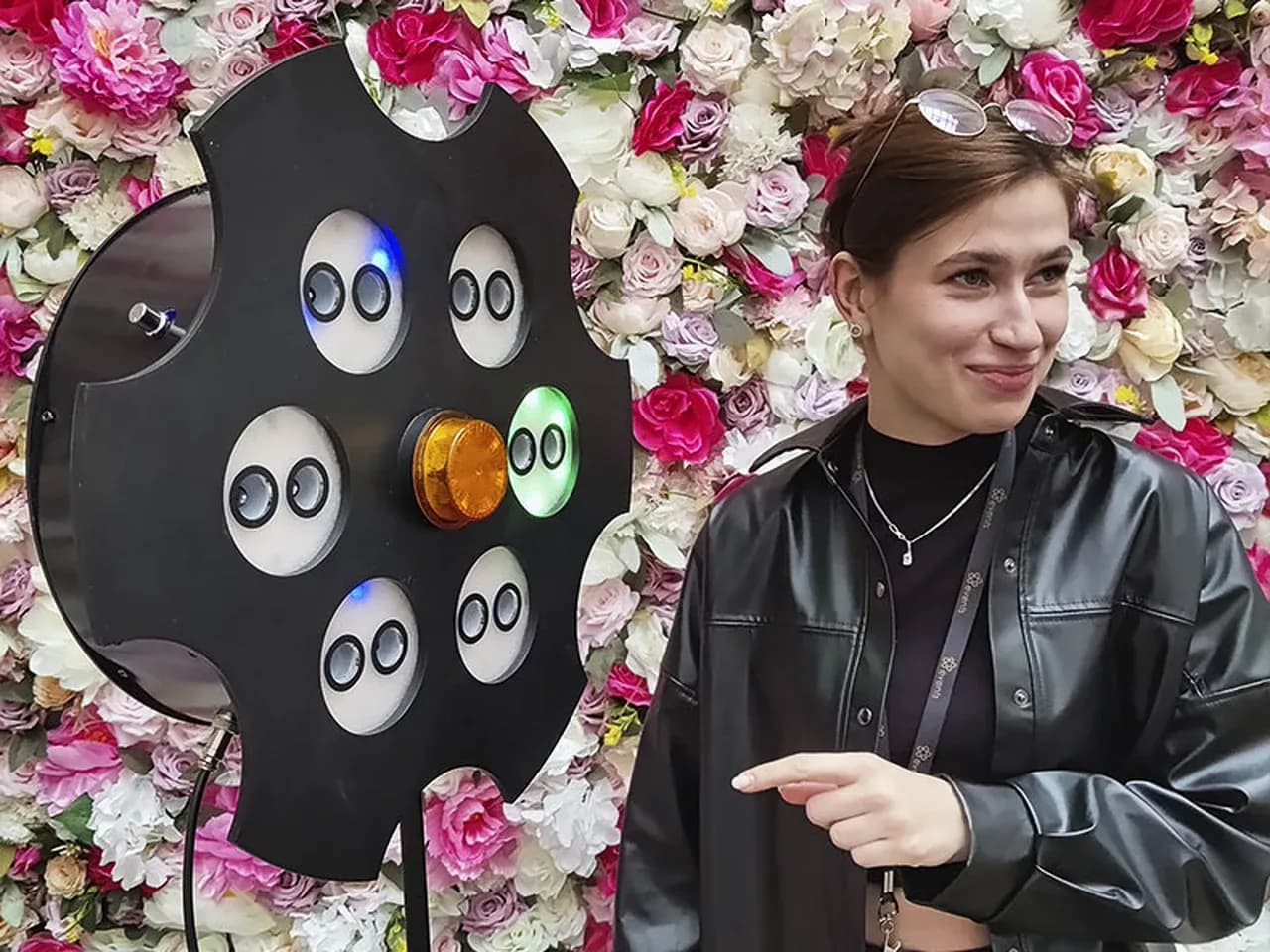 Русская розетка (рулетка): участница играет на фоне фотозоны с цветами