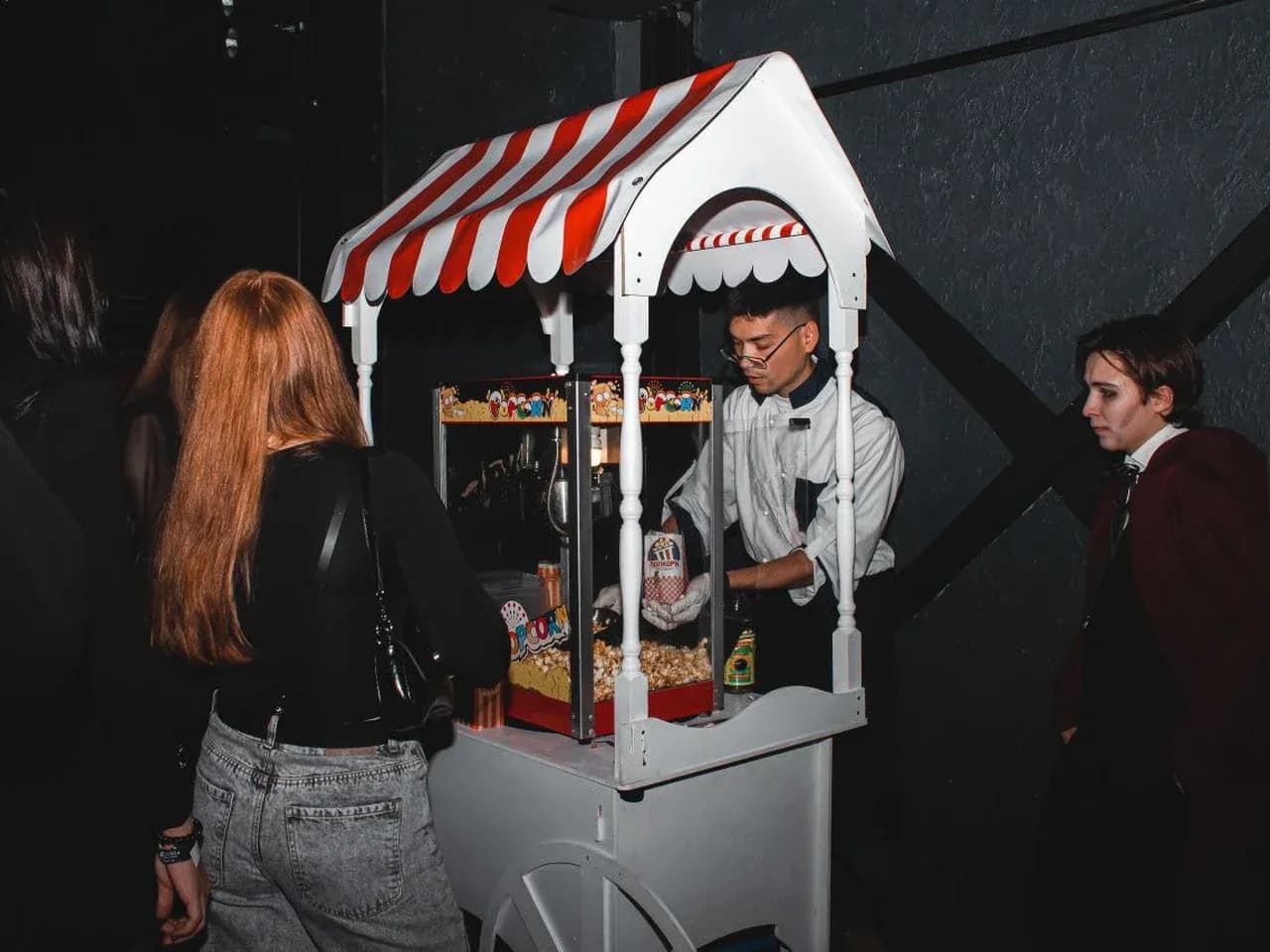 Оператор у тележки с попкорном: раздача попкорна гостям на мероприятии